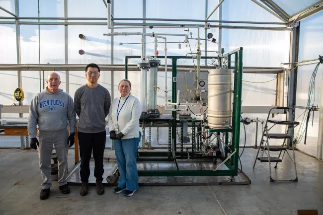 3 people standing in front of machinery