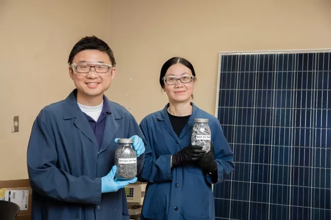Two students holding materials in mason jars